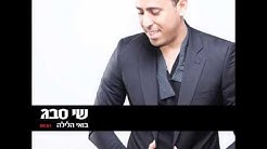 שי סבג בחליפה שחורה על רקע לבן